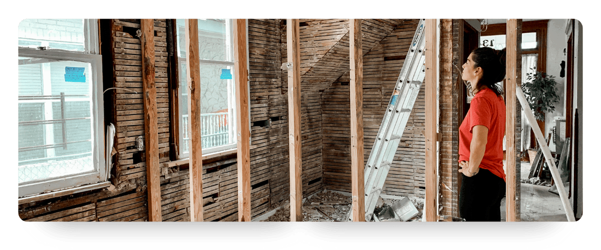 A women looking at the studs for a home retrofit project